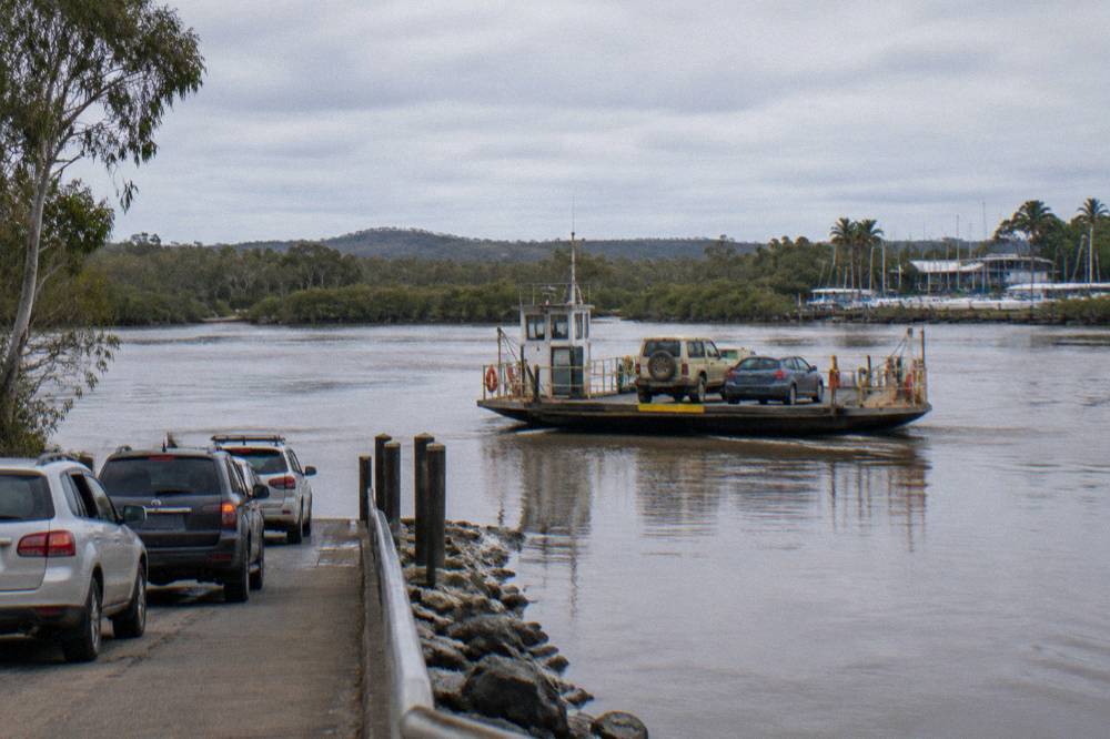Cable ferry crossing a wide river with vehicles on board