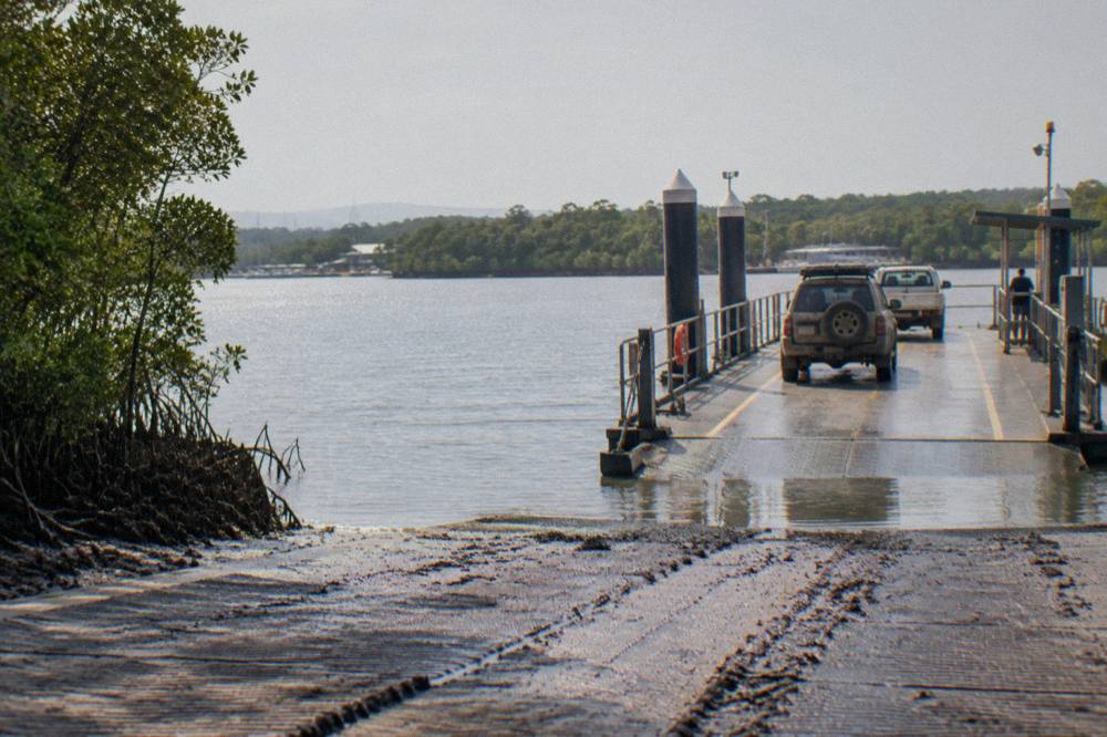 A vehicle ferry ramp at Tewantin with cars queued on the pontoon at midday