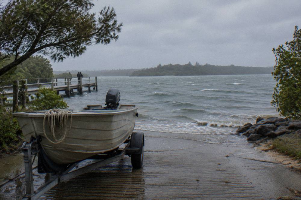 A quiet boat ramp at a lake edge with calm water and distant tree-lined shores