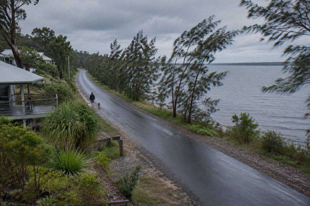 Sealed narrow road running beside a calm lake toward Boreen Point