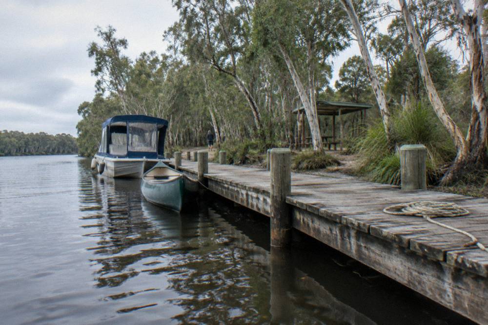 Canoe and cruise boat moored at a jetty on the upper Noosa River