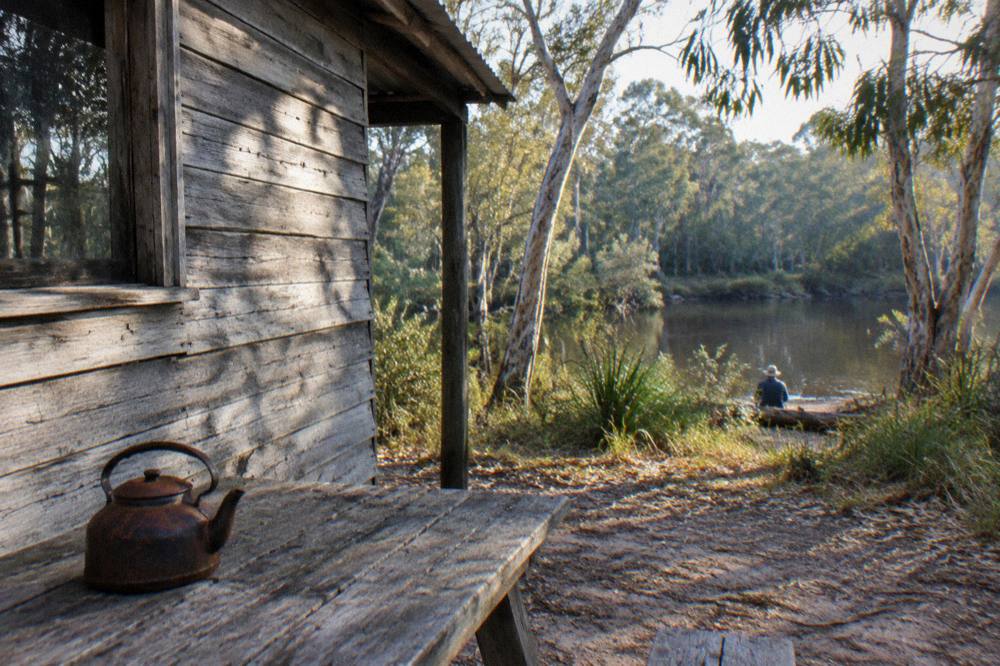 Old timber hut in a forest clearing beside the upper Noosa River